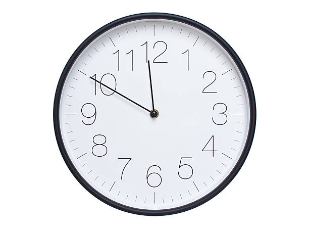 istock Simple wall clock with black frame and white face displaying 11:50 or 23:50. Ideal for time, schedule, and punctuality themes. 2209850707