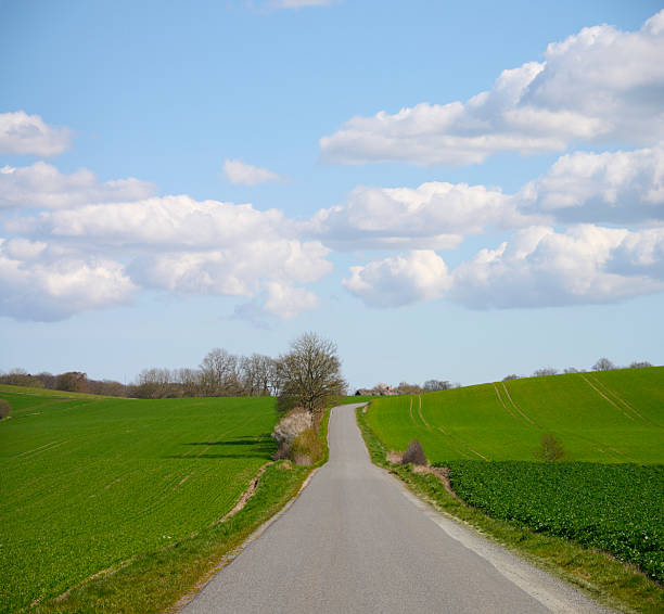 istock Blue sky and white clouds over single lane road 2209853680