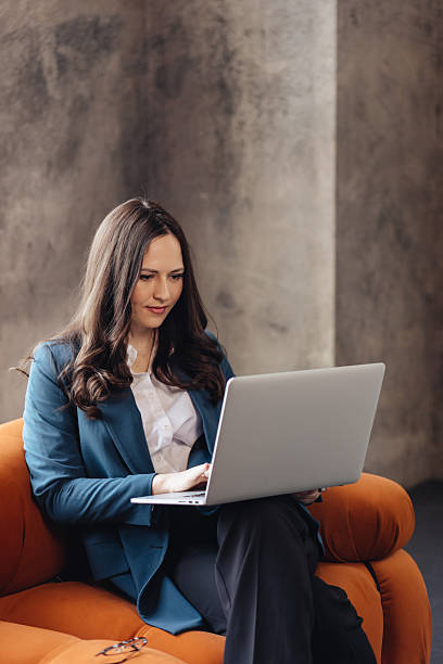 istock Confident Businesswoman Working on Laptop in a Modern Office Space 2209854319