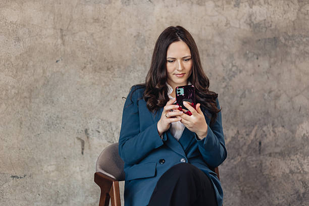 istock Confident businesswoman using smartphone while sitting in modern office space horizontal photography 2209854330