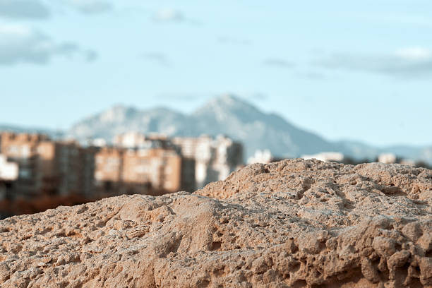 Urban landscape with sandy foreground and distant mountains.