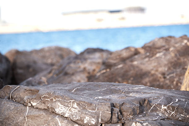 Natural rocky beachfront with blurred horizon and blue sea.