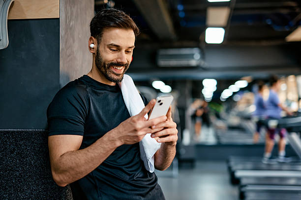 istock Smiling sportsman using smartphone at the gym 2209855584