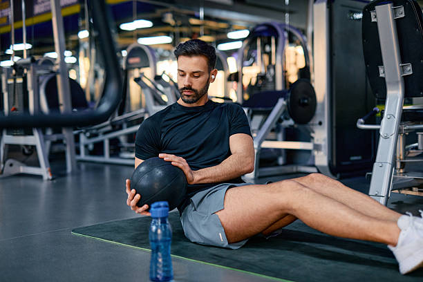 istock Determined athlete doing sit-ups with medicine ball in gym 2209855604