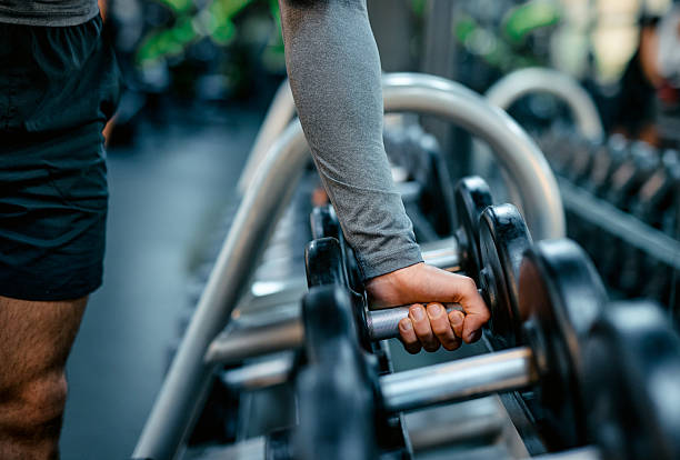 istock Athlete grabbing dumbbell in gym for weight training 2209855723