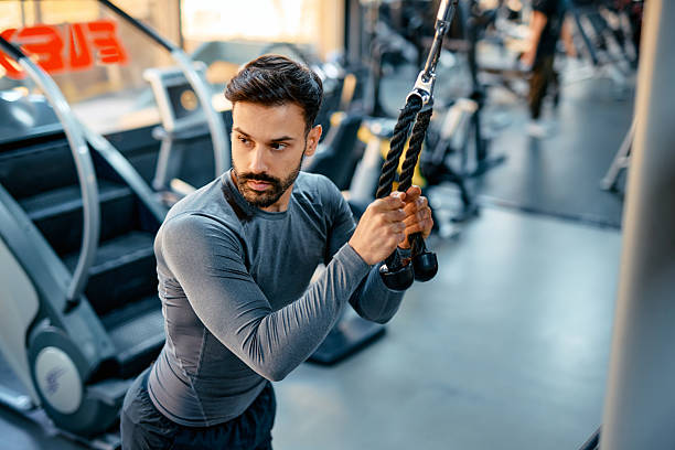 istock Determined sportsman exercising with ropes in a gym 2209855770