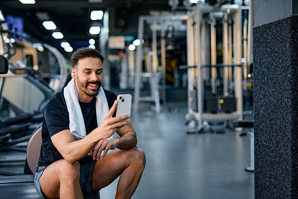 istock Smiling sportsman using smartphone in gym after training 2209856002