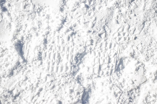 Snow surface with shoe prints and other traces in natural light, Texture backgrounds