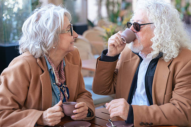 istock Caucasian senior couple talking closely while drinking coffee at outdoor cafe 2209864991