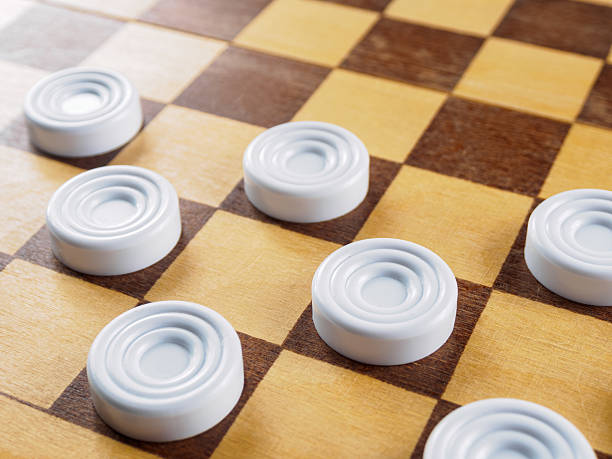 istock Checkers game setup on a checkered board. Strategy, game pieces, black and red, ready to play, board game. 2209865123