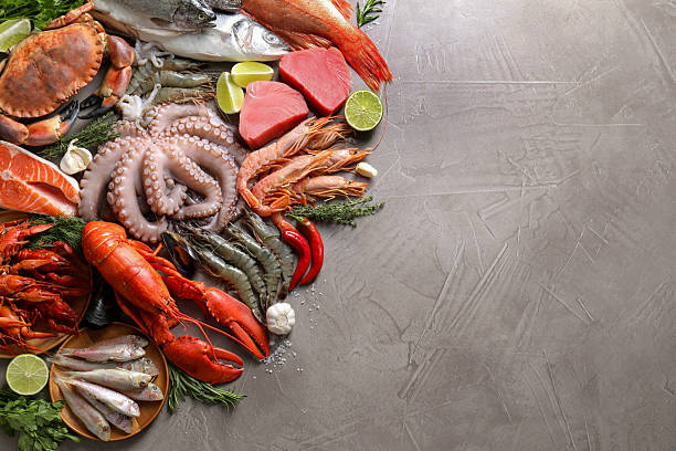 istock Many different sea food, herbs, garlic and lime on grey table, flat lay. Space for text 2209865700
