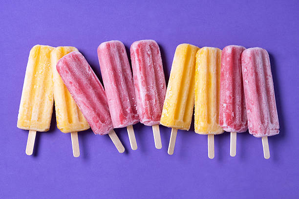 istock Orange and pink popsicles on purple background 2209866312