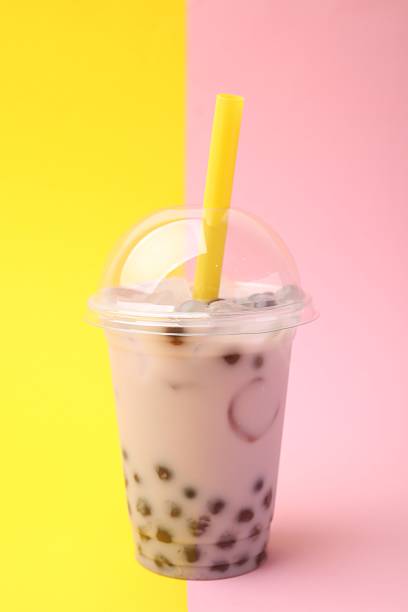 istock Tasty milk bubble tea in plastic cup on color background 2209869364