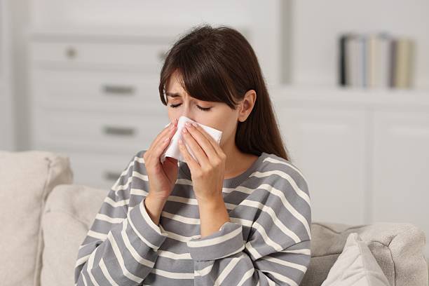 istock Woman with napkin suffering from sinusitis on sofa at home 2209869543