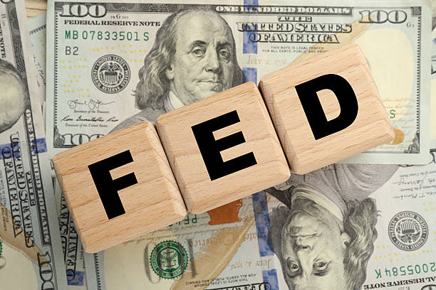 istock Cubes with letters Fed (Federal Reserve System) and dollar banknotes, top view 2209870935