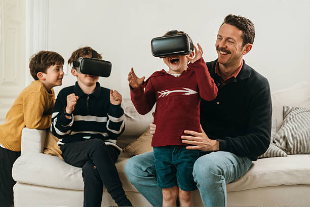 Father and son having a fun at home with VR goggles