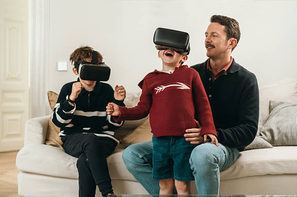 Father and son having a fun at home with VR goggles