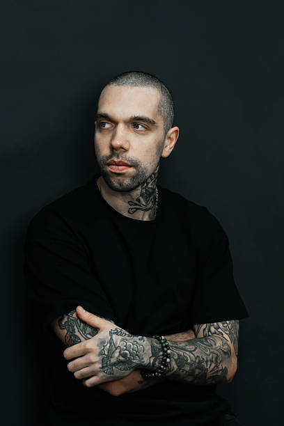 istock Tattooed Man with Intense Expression on Dark Background. Vertical photo 2209879075