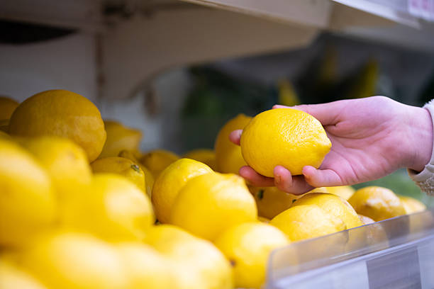 istock Female shopper's hand choosing lemons 2209889889