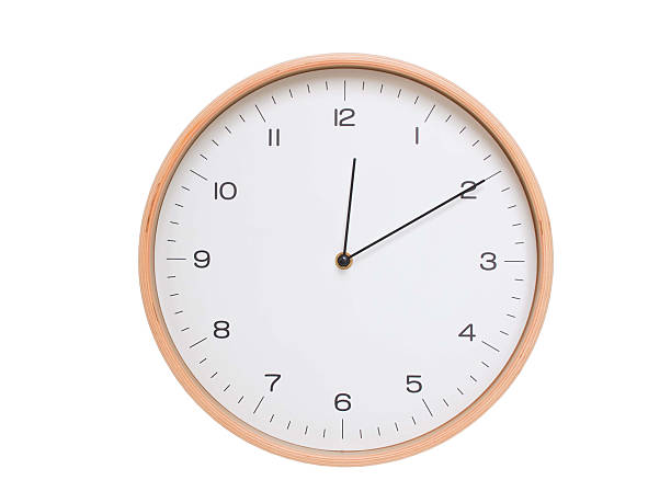 istock Minimal wall clock with light wood frame and white face displaying 00:10 or 12:10. Perfect for clean, modern concepts about time and scheduling. 2209902238