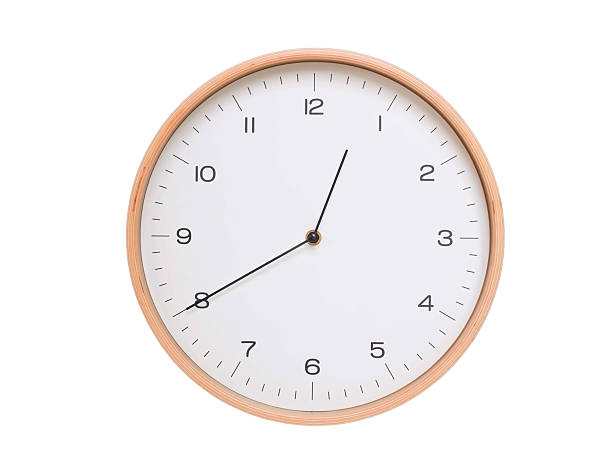 Round wall clock with black frame showing time at 00:40 or 12:40. Ideal for concepts of time or scheduling.