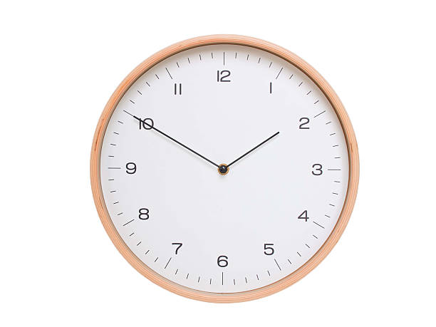 Minimal wall clock with light wood frame and white face displaying 01:50 or 13:50. Perfect for clean, modern concepts about time and scheduling.