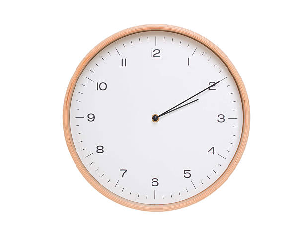 Minimal wall clock with light wood frame and white face displaying 02:10 or 14:10. Perfect for clean, modern concepts about time and scheduling.