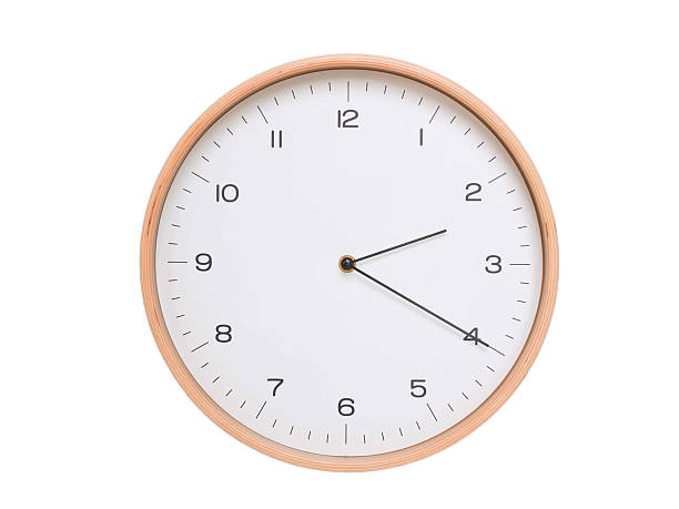 Minimal wall clock with light wood frame and white face displaying 02:20 or 14:20. Perfect for clean, modern concepts about time and scheduling.