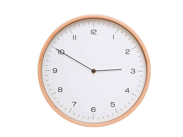 Minimal wall clock with light wood frame and white face displaying 02:50 or 14:50. Perfect for clean, modern concepts about time and scheduling.