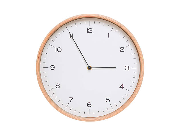Minimal wall clock with light wood frame and white face displaying 02:55 or 14:55. Perfect for clean, modern concepts about time and scheduling.