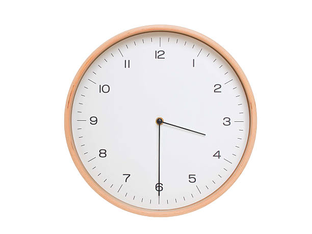 Minimal wall clock with light wood frame and white face displaying 03:30 or 15:30. Perfect for clean, modern concepts about time and scheduling.