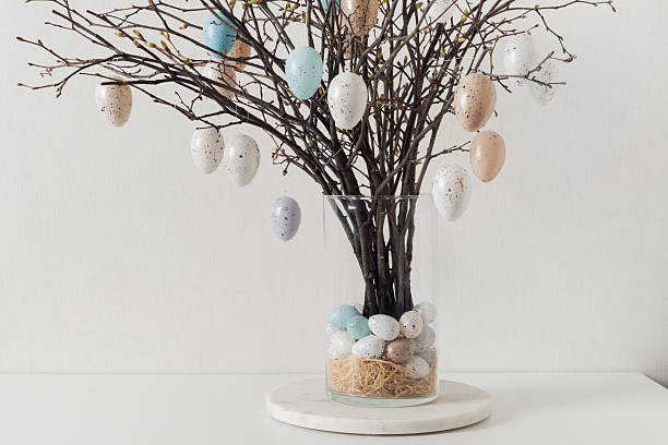 istock Easter tree decorated white and beige eggs in vase on white table. 2209908134