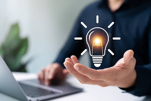 istock Innovation through ideas and inspiration ideas. Human hand holding light bulb to illuminate, idea of creativity and inspiration concept of sustainable business development. 2209914086