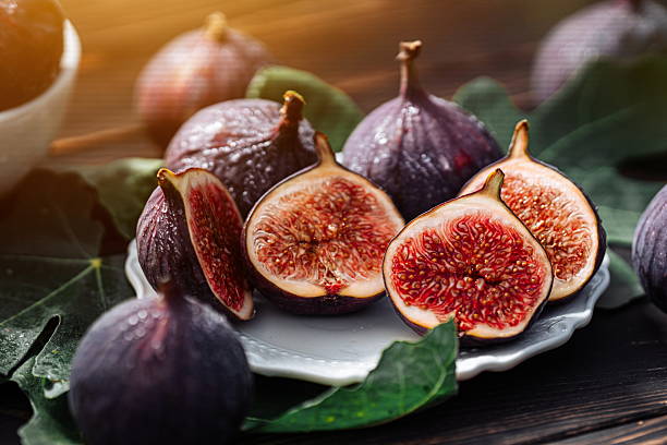 istock Delicate Fresh Ripe Figs With Leaves On White Plate, Rustic Wooden Table. Ficus 2209914976