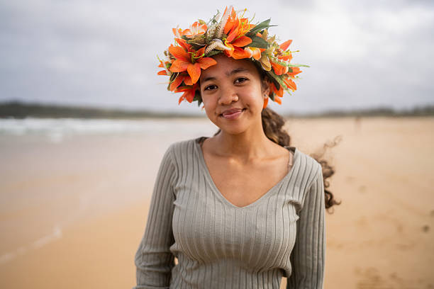 Portrait of a teenage girl standing by the ocean, wearing a handmade flower crown.