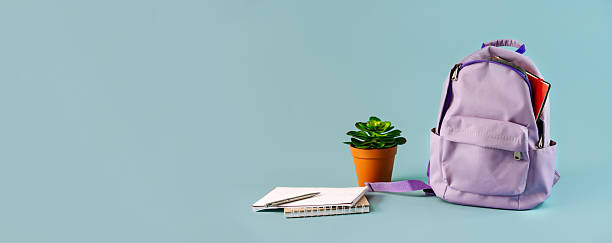 istock A backpack filled with stationery with flowers on an isolated blue background with a place for text, the September 1 concept for schoolchildren and students, perfect for back-to-school or educational promotions. 2209923952