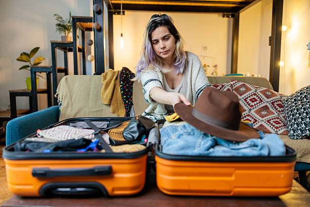istock Woman Folding Clothes Into Suitcase 2209929845