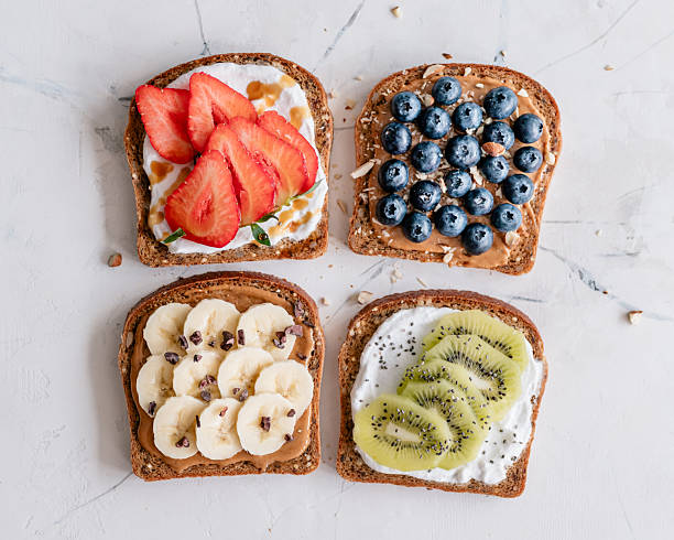 istock Four toasts with peanut butter, cream cheese and fruit 2209936171