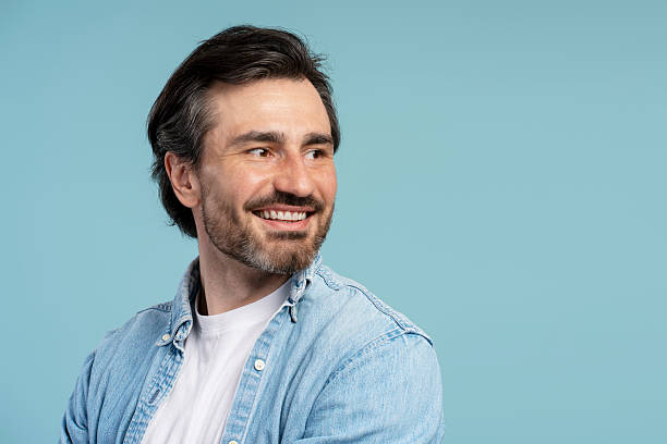 istock Smiling middle aged, bearded man looking away on blue background, copy space 2209937623