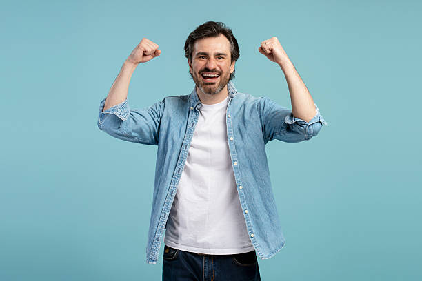 istock Excited middle aged man showing strength and happiness on blue background 2209937643
