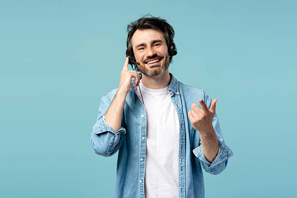 istock Smiling male call center agent wearing headset assisting customer on blue background 2209937679
