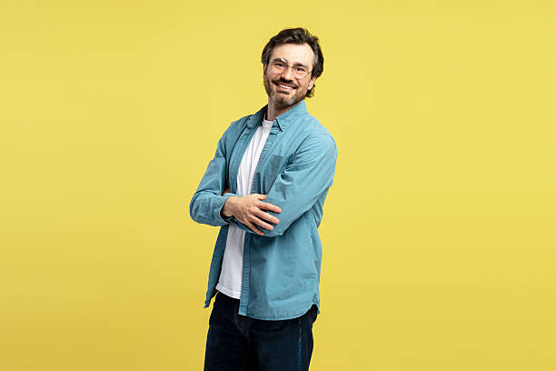 istock Smiling, handsome middle aged man crossing arms on yellow background 2209941168
