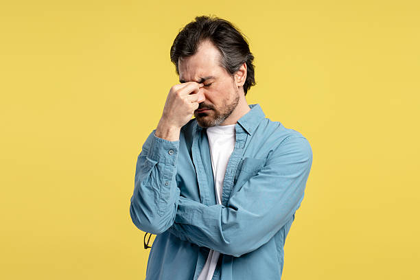 istock Stressed businessman suffering from headache massaging his nose bridge 2209941183