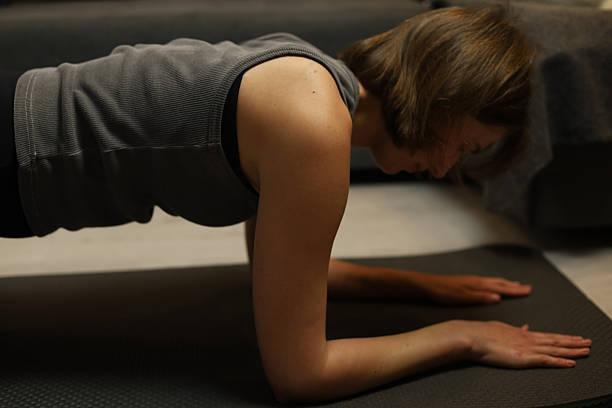 istock woman doing plank on yoga mat at home 2209941450