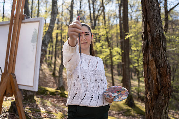 istock Artist Painting Outdoors in Forest During Springtime with Bright Natural Lighting 2209951027