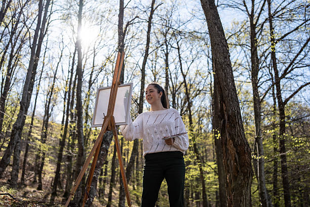 istock Artist Painting on Easel in Serene Forest Outdoor Setting 2209951085
