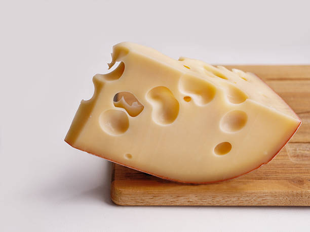 istock cheese with big holes on wooden cutting board, copy space 2209958730