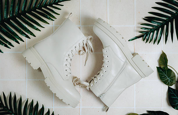 Woman boots on tiled floor with green leaves.