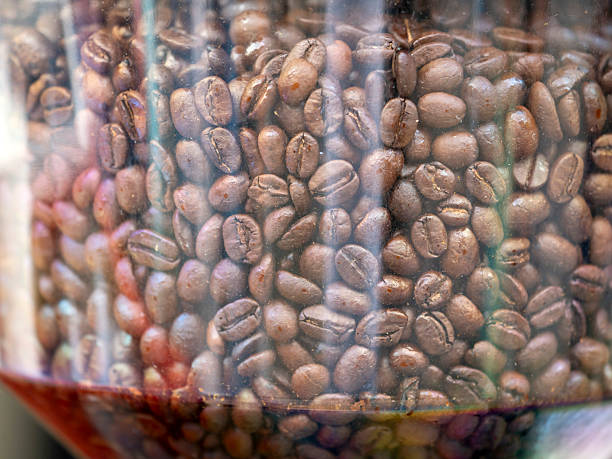 a different coffee beans in glass jars on a white surface.