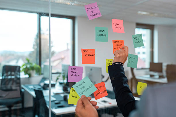 istock Hands Arranging Colorful Sticky Notes On Glass Wall In Modern Office Workspace 2209969813
